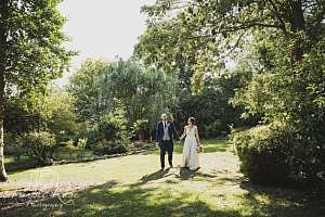 Bride and groom walking through a garden