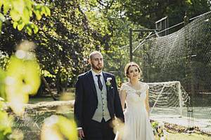 Bride and groom walking round a garden