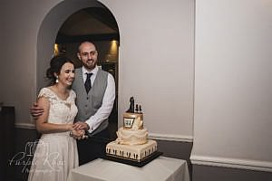 Bride and groom preparing to cut their wedding cake