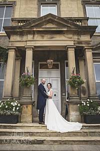 Bride and groom standing under door archway