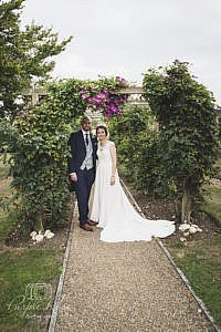 Bride and groom standing among flowers