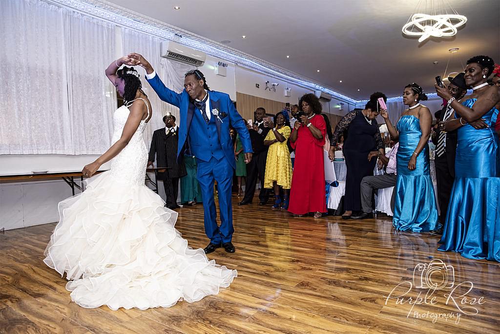 Groom twirling his bride on the dance floor