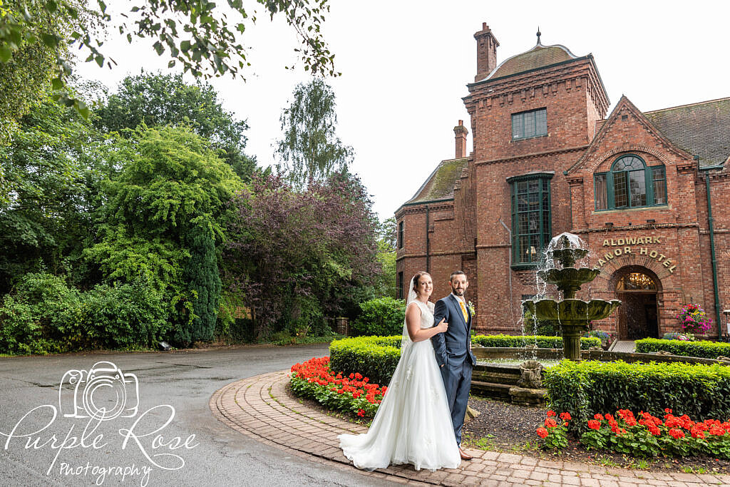 Bride and groom in front of a manor house