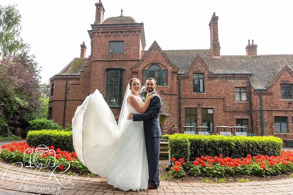 Bride and groom embracing in front of their wedding venue