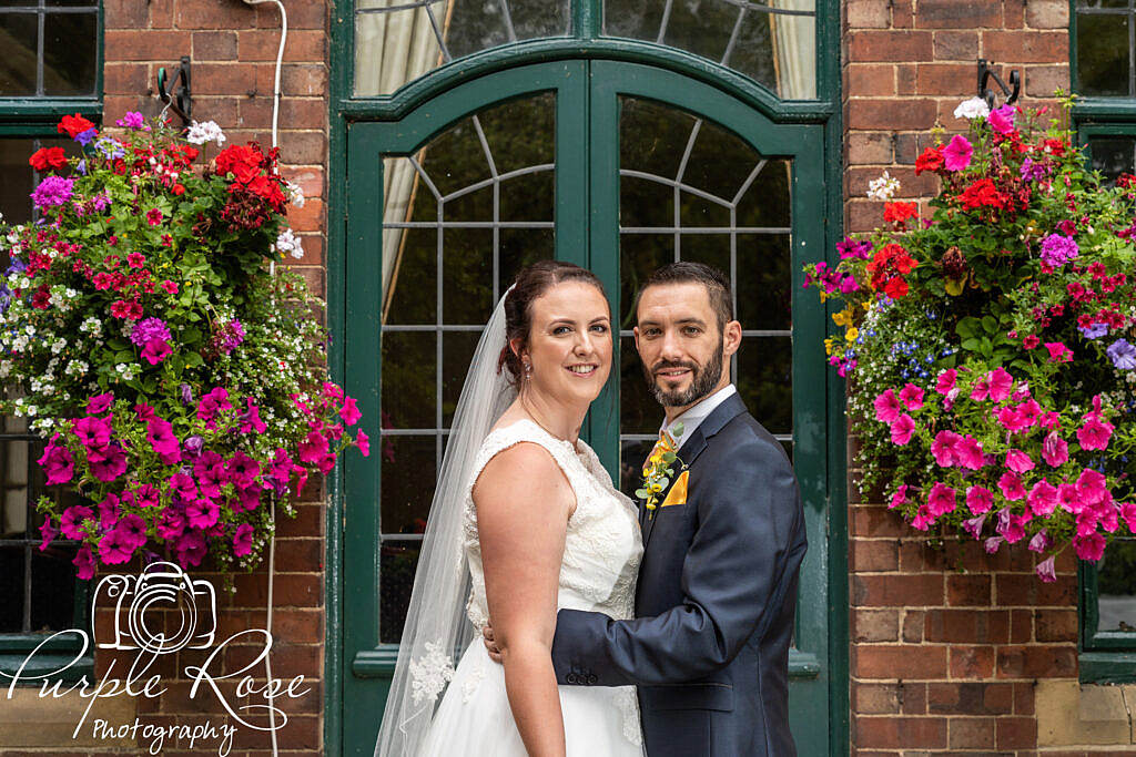 Bride and groom surrounded by hanging baskets