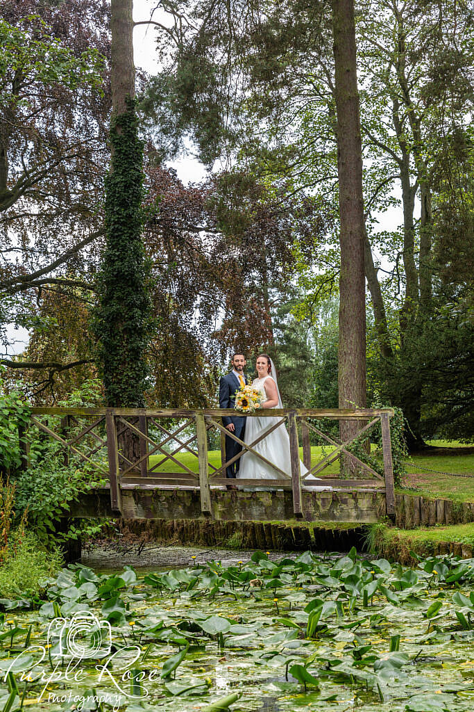 bride and groom on a wooden bridge