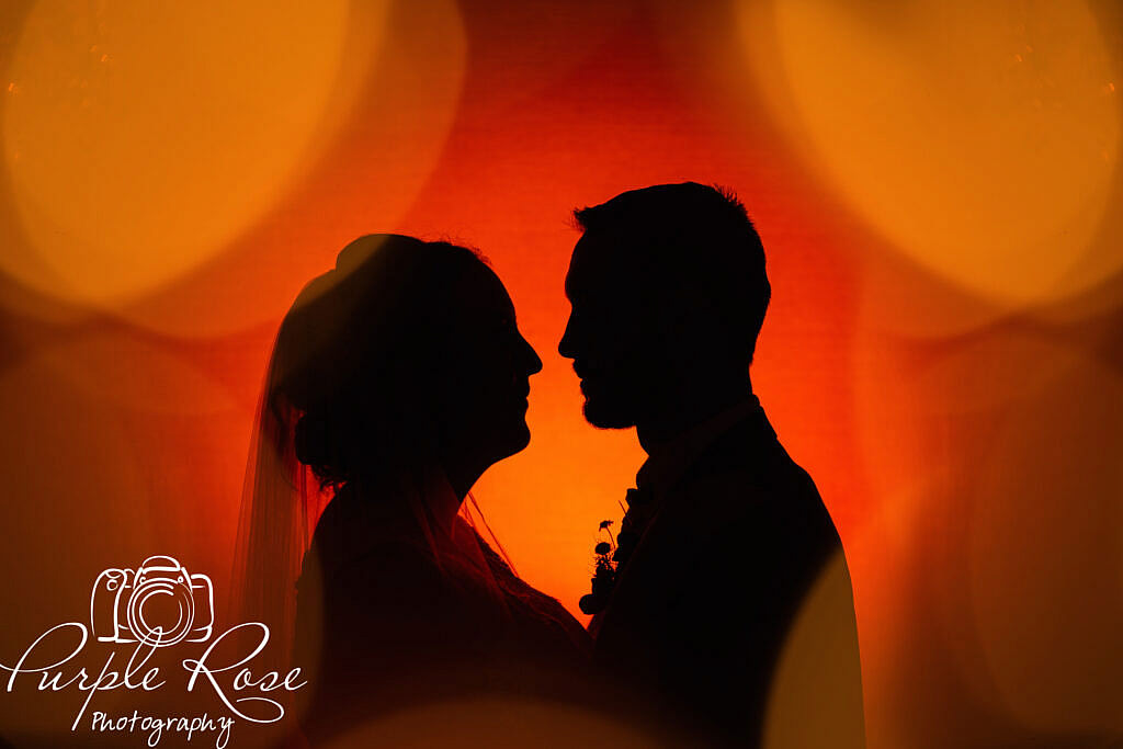 Orange background silhouette of bride and groom