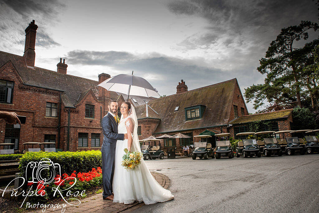 Bride and groom sheltering from the rain.