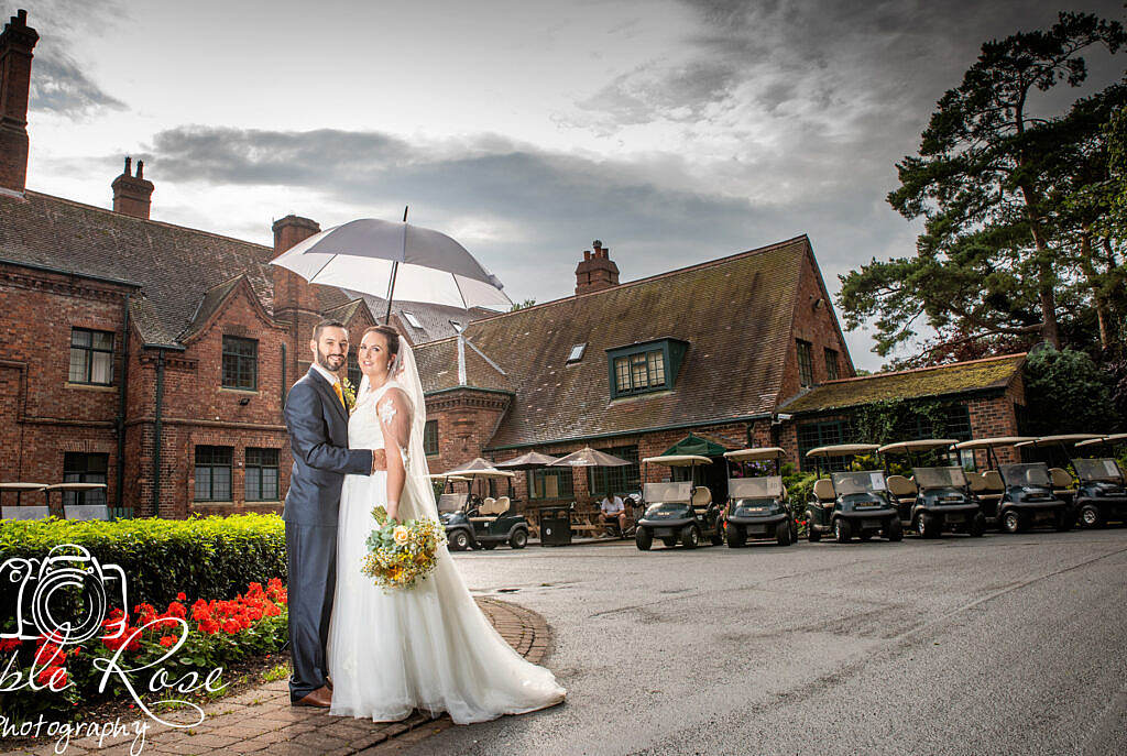 Bride and groom sheltering from the rain.