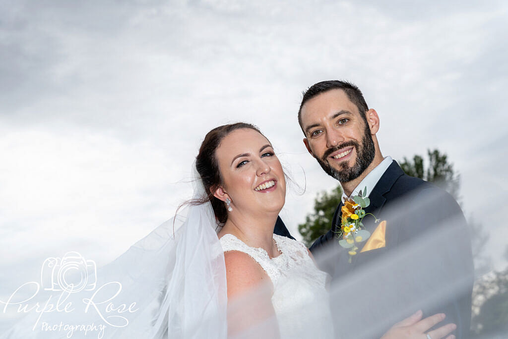 Brides veil swirling around the couple