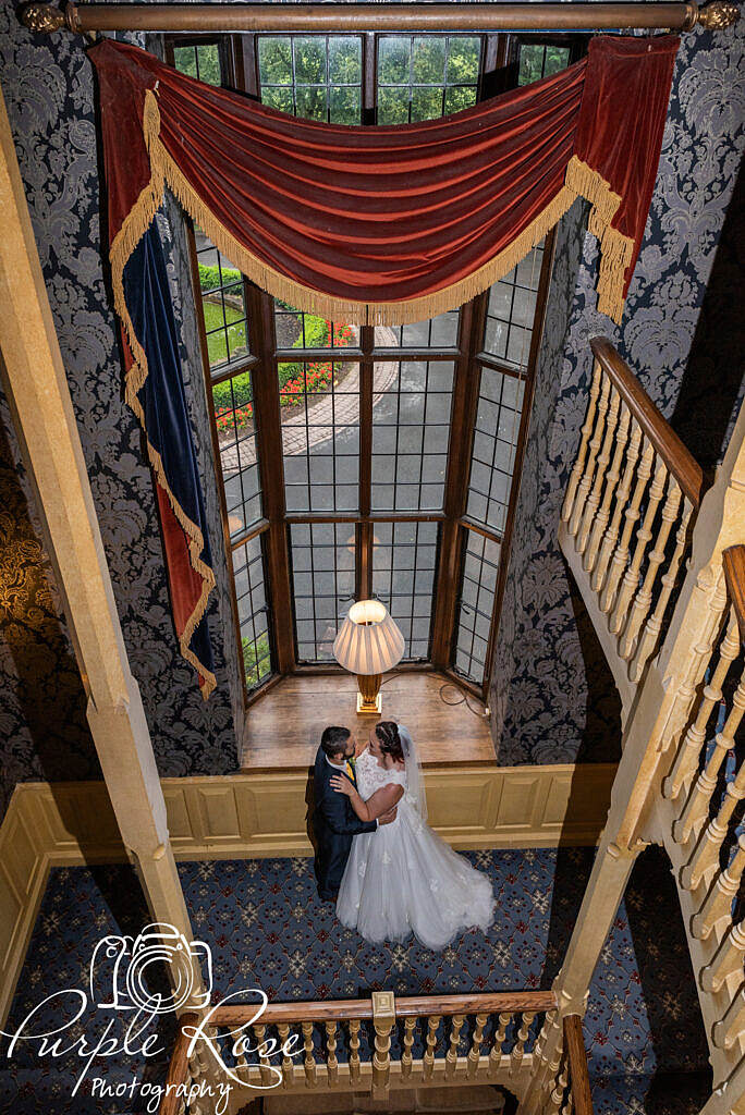 Bride and groom in front of a grand window