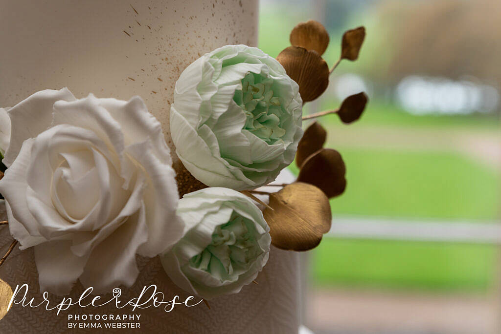 Intricate hand made flowers on a wedding cake in Kelmarsh Hall Northampton