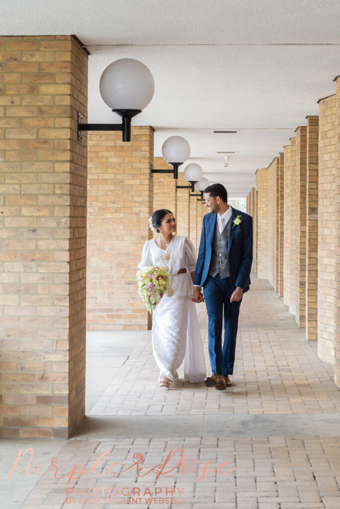 Bride and groom walking hand in hand after their wedding ceremony in Milton Keynes
