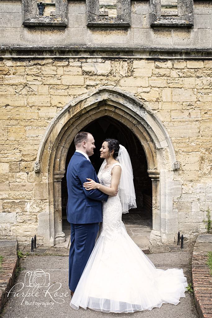 Bride and groom looking into each others eyes in front of the church