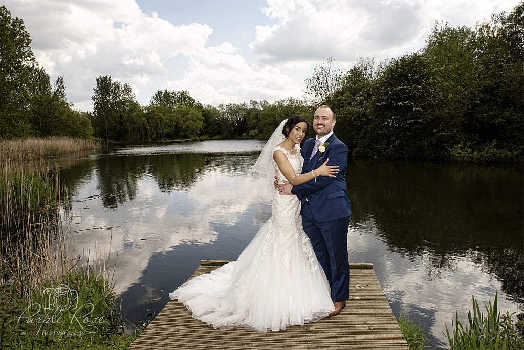 Bride and groom standing on a lakeside