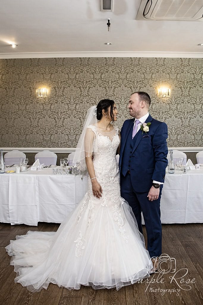 Bride and groom standing in their wedding reception room