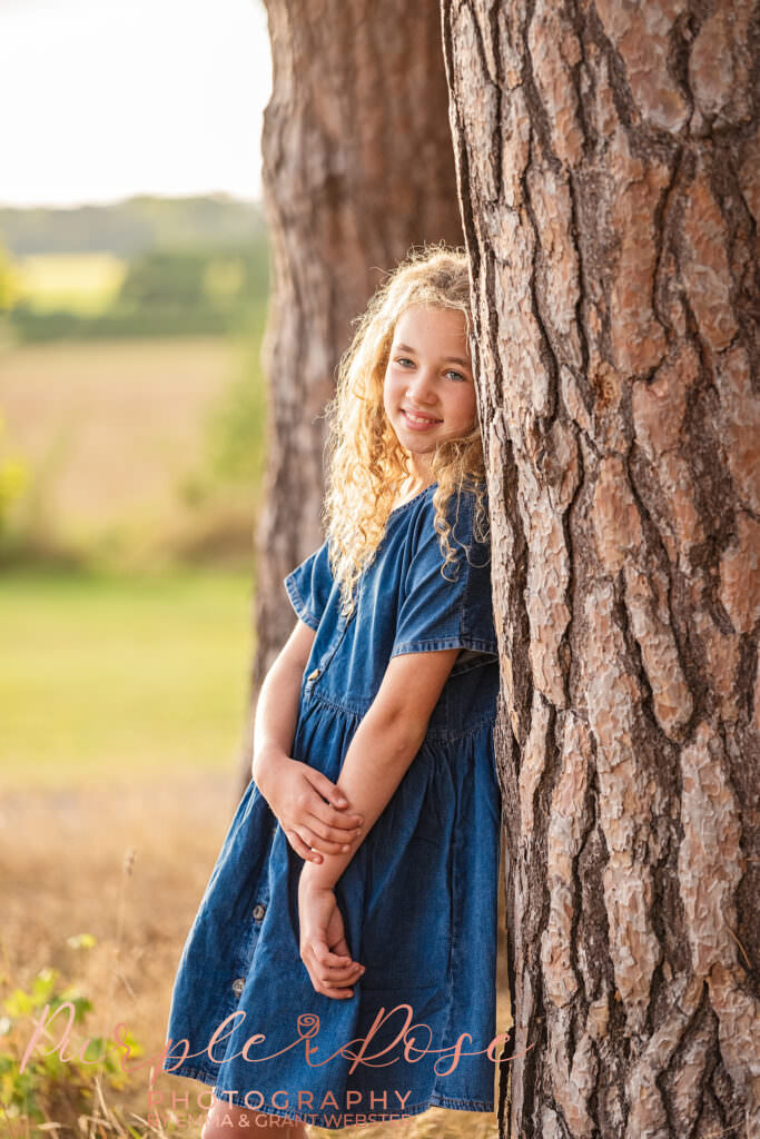 Girl leaning against a tree