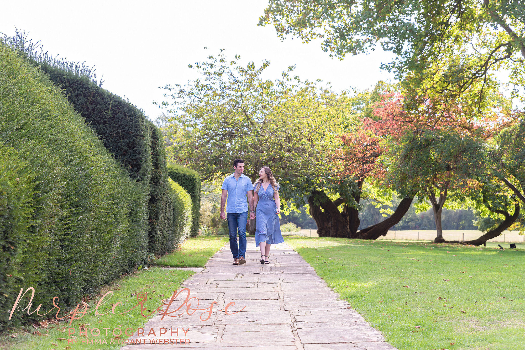 Couple walking hand in hand along a pathway