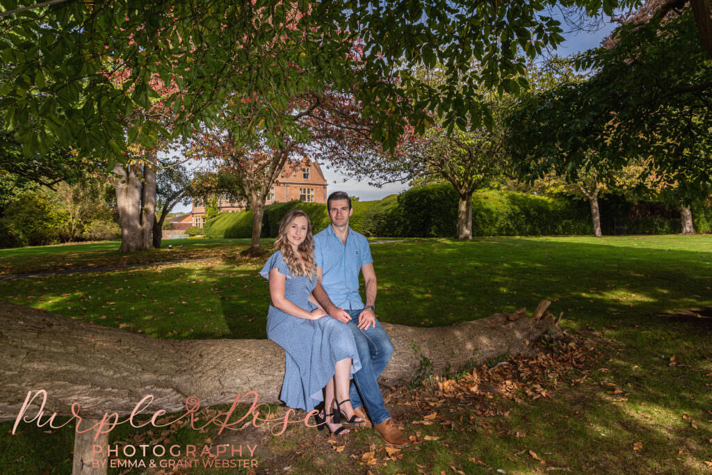 Couple sat on a fallen tree branch