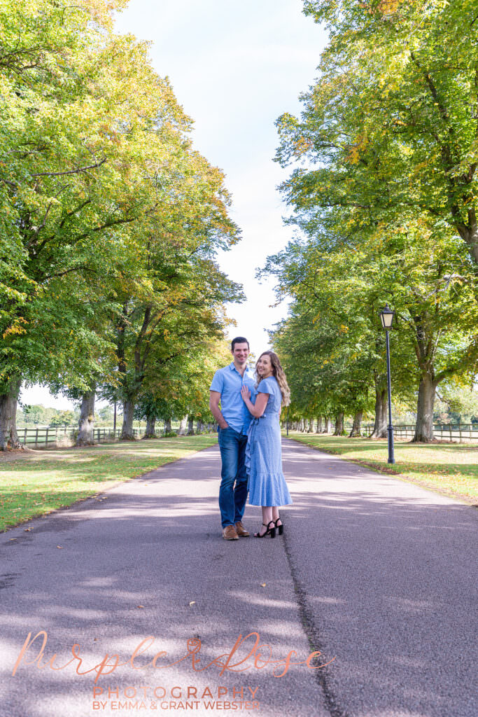 Couple stoof in tree lined drive way