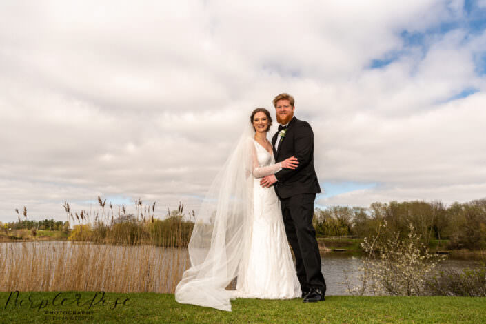 Bride and groom stood by a lake side