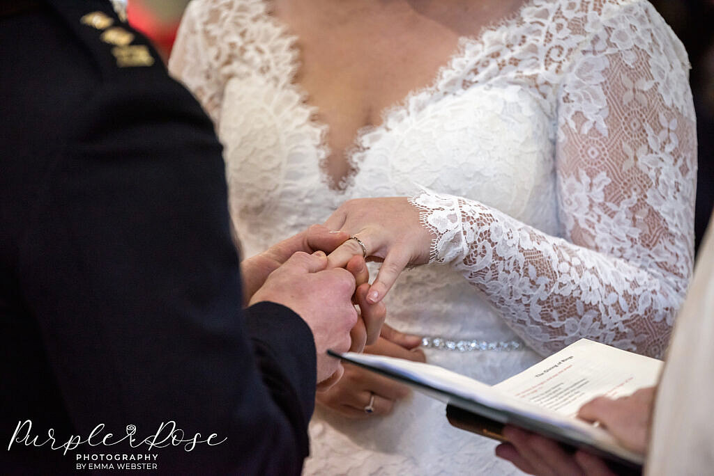 Groom placing ring on brides finger