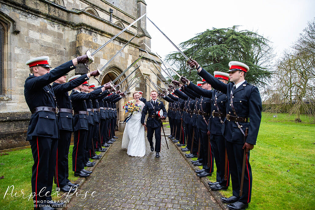 Bride and groom walking under swords