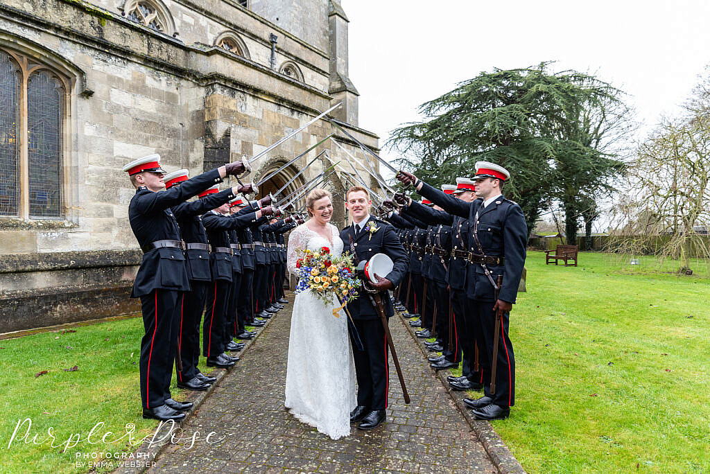 Bride and groom in front of sword arch