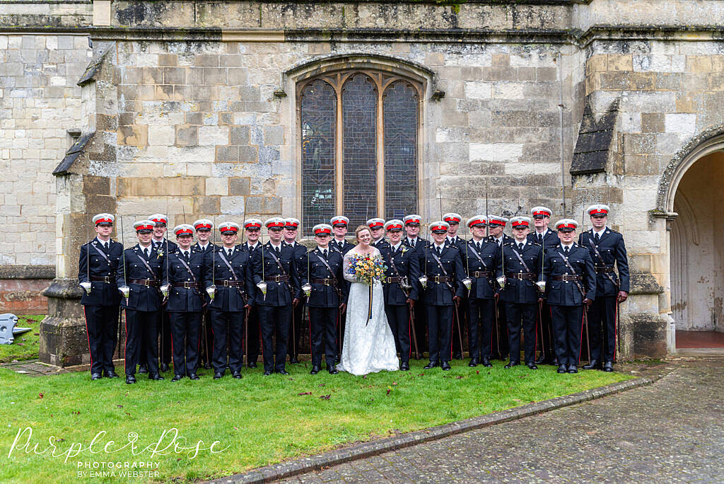 Bride and groom posing with military freinds