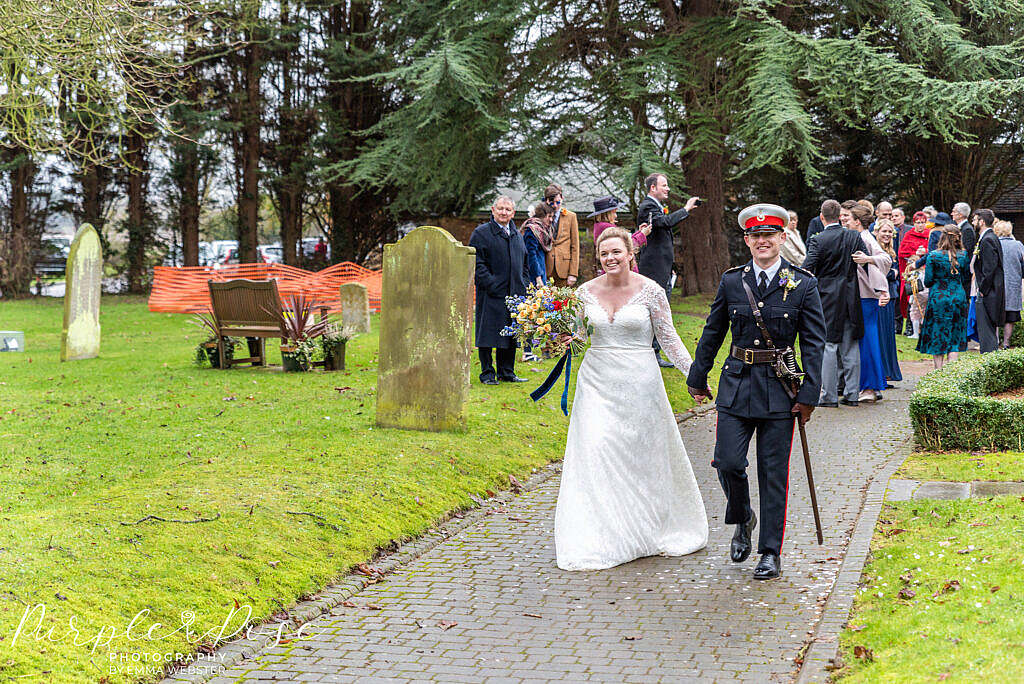 Bride and groom walking from the church