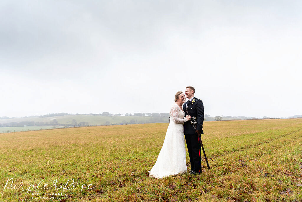 bride and groom standing in a field