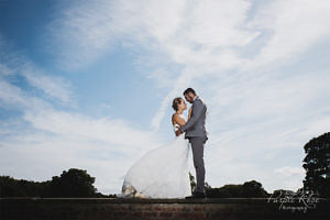 Bride and groom stood on a wall