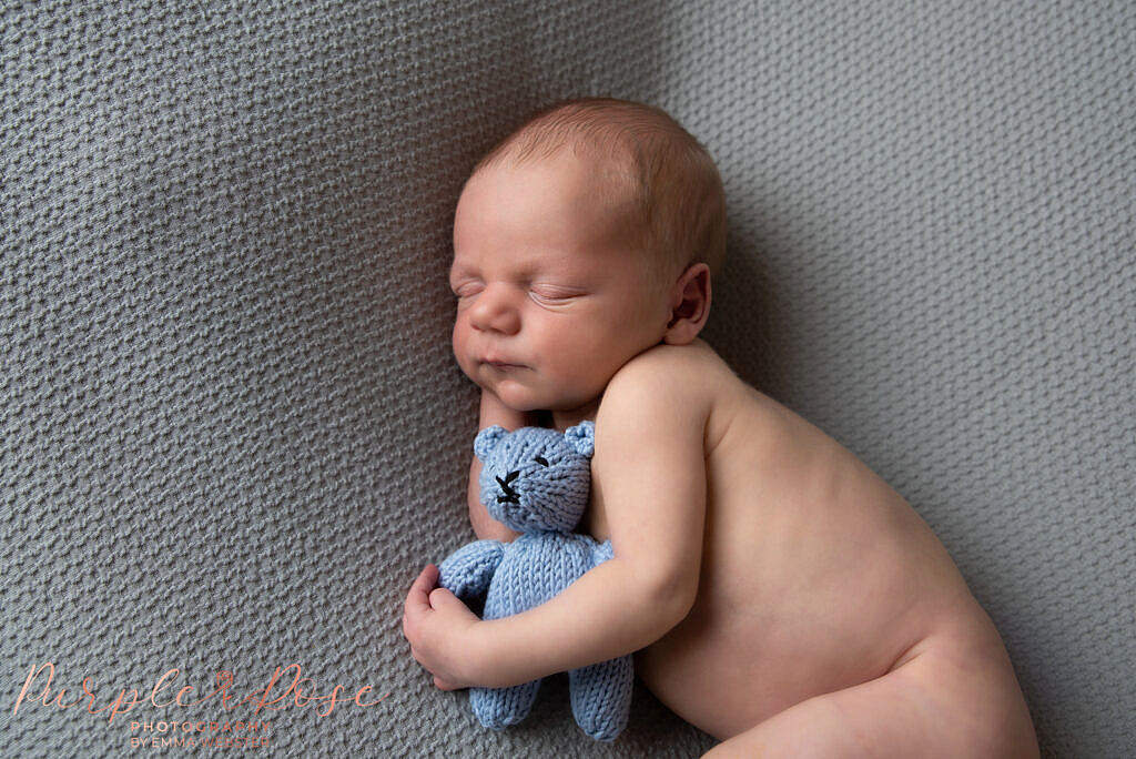 Baby boy sleeping with teddy