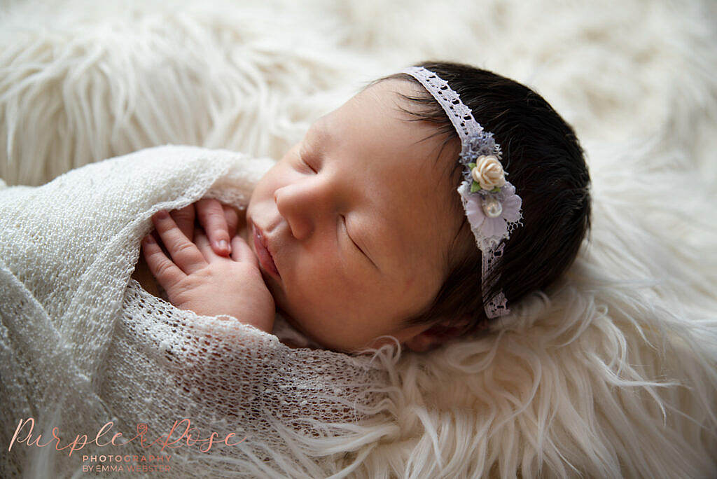 New born baby asleep in a wrap at her photoshoot in Milton Keynes