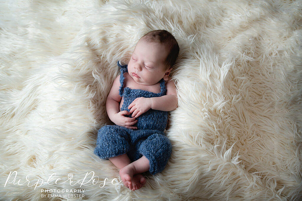 Baby sleeping in a blue romper