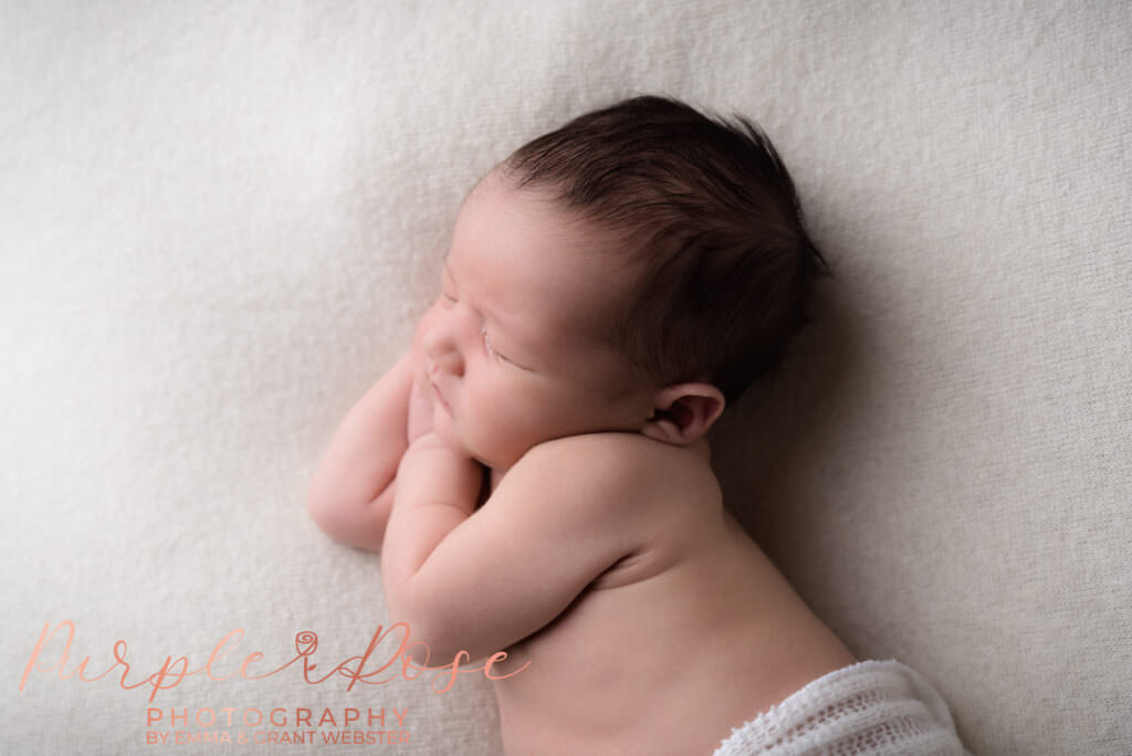 Photo fo a newborn baby sleeping during his photoshoot in Milton Keynes