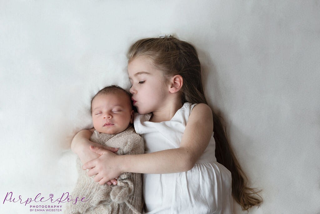 Big sister kissing her baby sister