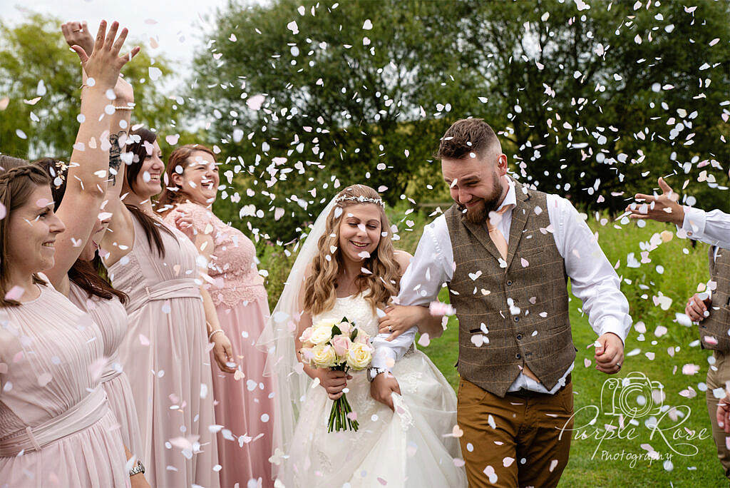 Bride and groom being showered in confetti