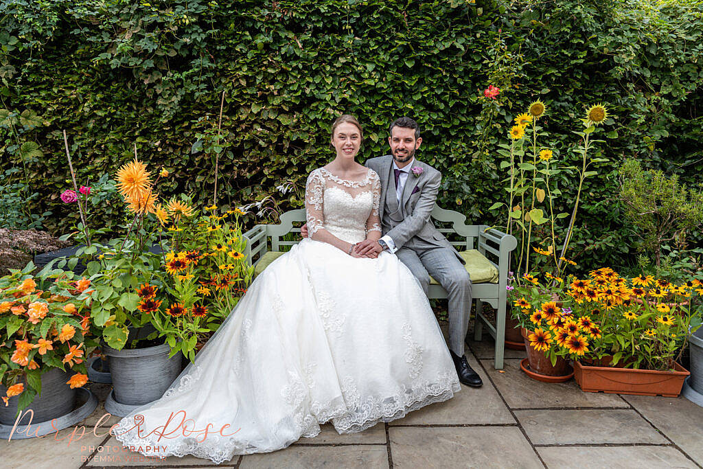 Couple sat in garden of flowers