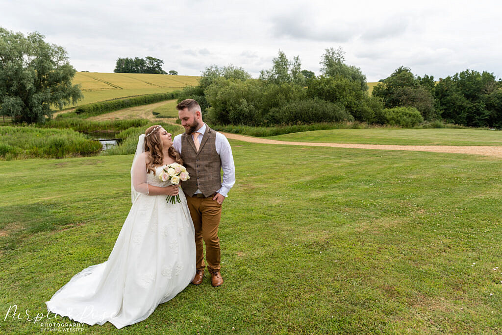 Bride and groom surrounded by countryside
