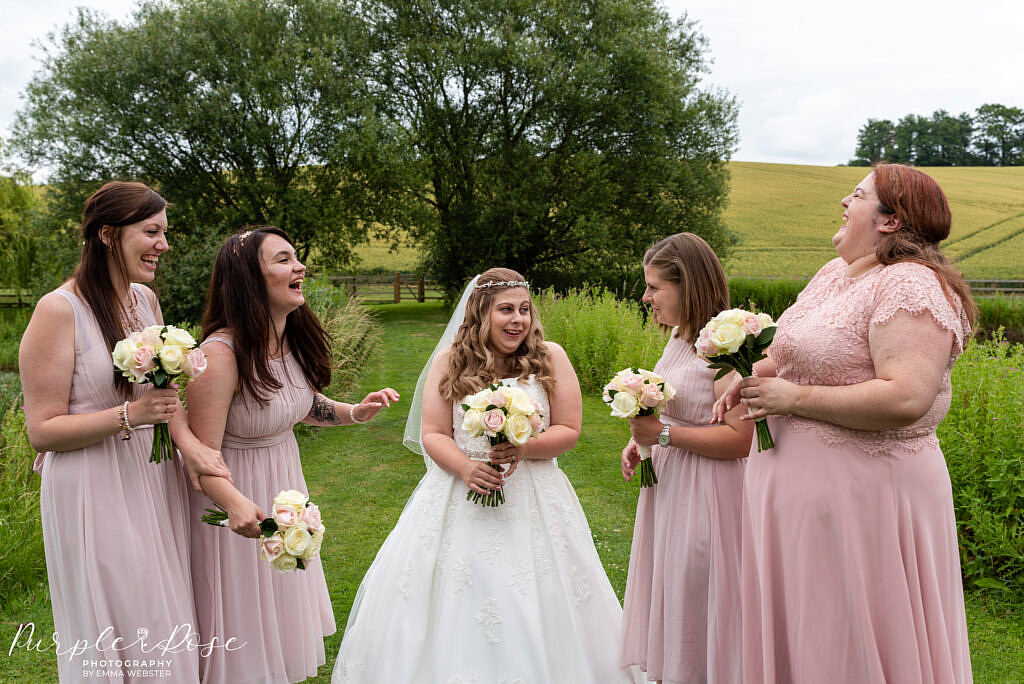 Bride laughing with her bridesmaids