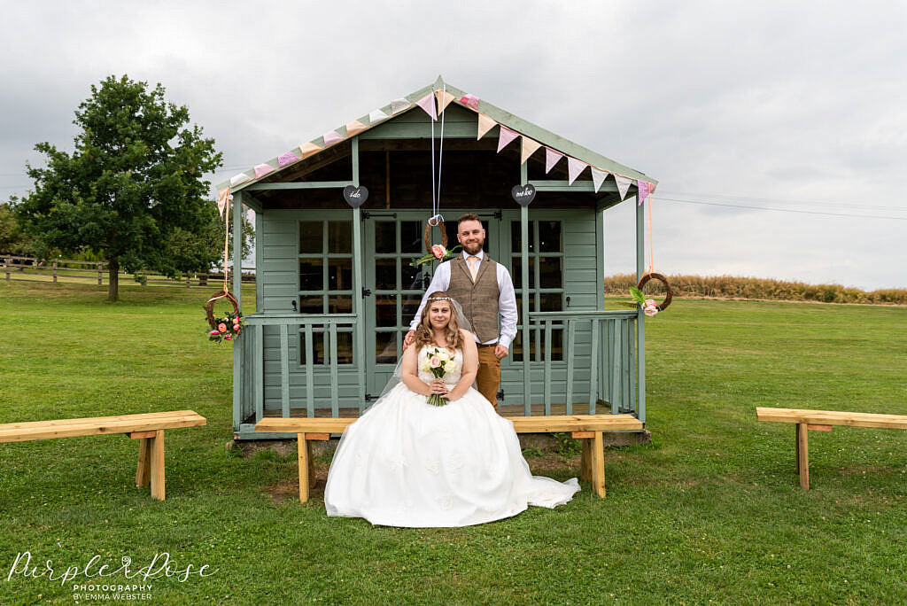 Bride and groom in front of pretty hut