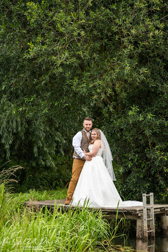 Bride and groom standing together on a fishing platform