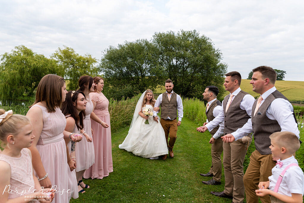 bride and groom surrounded by wedding party