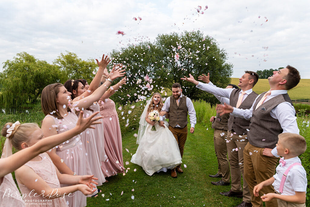 Bride and groom walking through confetti