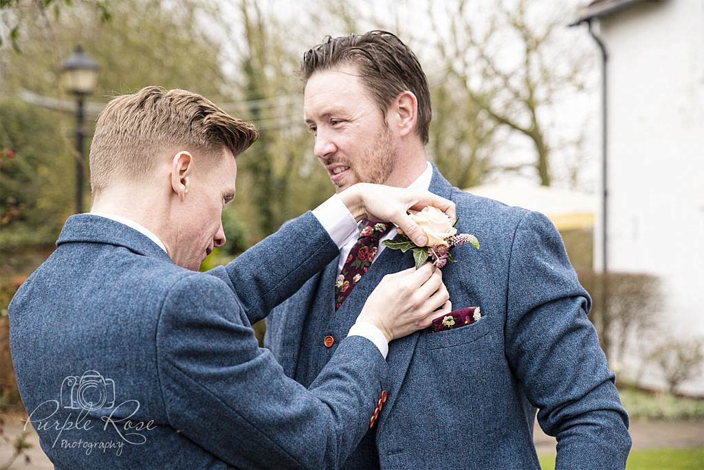 Best man pinning the Grooms button hole