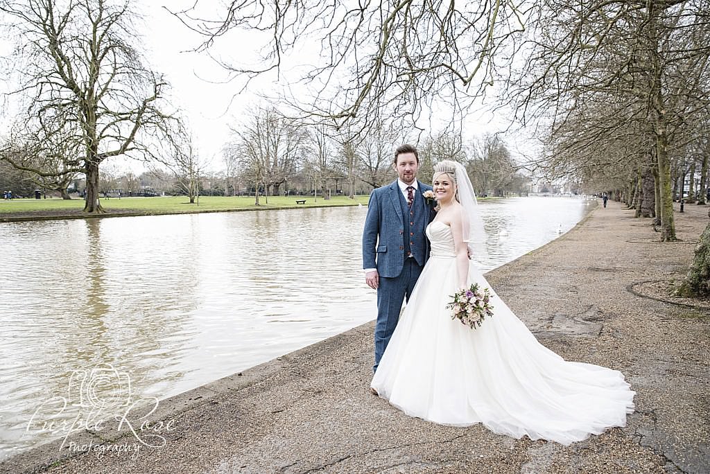 Bride and groom Standing by Bedford river bank