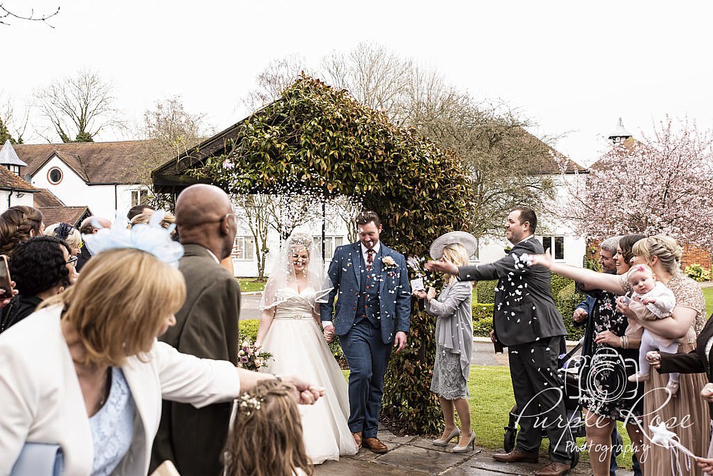 Bride and groom being showered in confetti