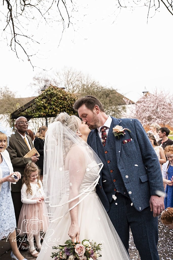 Bride and groom being showered in confetti