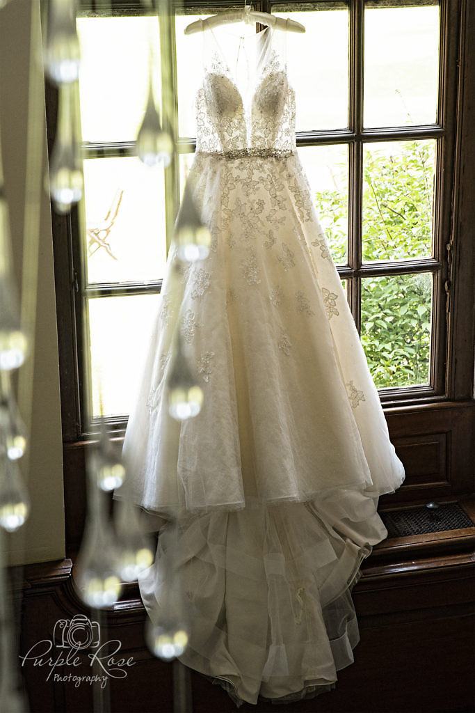 Wedding dress hanging in a window at Chicheley Hall